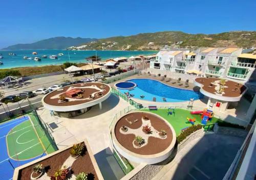 Un resort con piscina y el océano. en Cobertura com Piscina Privativa em Resort Pé na Areia, en Arraial do Cabo