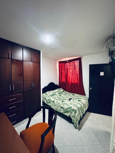 a small bedroom with a bed and a red curtain at Habitacion privada cerca al hospital de Neiva con Aire Acondicionado y baño Privado in Neiva