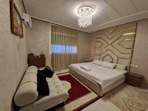 une chambre avec un grand lit et un canapé dans l'établissement Premium Luxury Family Home in Downtown Meknes, à Meknès