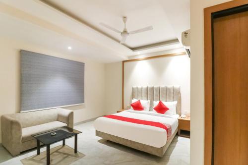 a bedroom with a bed and a chair at Hotel Premium Suites Near Delhi Airport in New Delhi