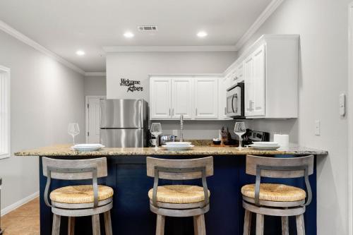 グルーエーヌにあるClose to River Shared Family Pool Wurstfest Readyの白いキャビネット付きのキッチン、バースツール付きのカウンター