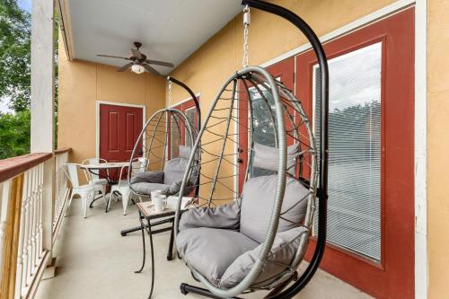 a porch with two chairs and a swing at Close to River Shared Family Pool Wurstfest Ready in New Braunfels
