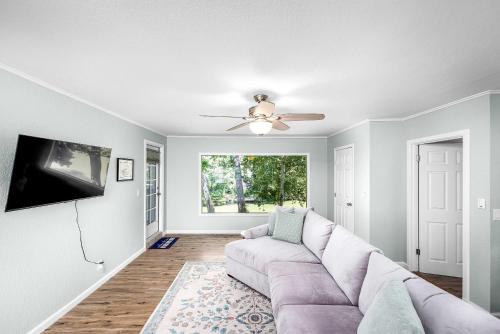 a living room with a couch and a flat screen tv at Riverfront Private Deck Family Games Wurstfest Fun in Seguin