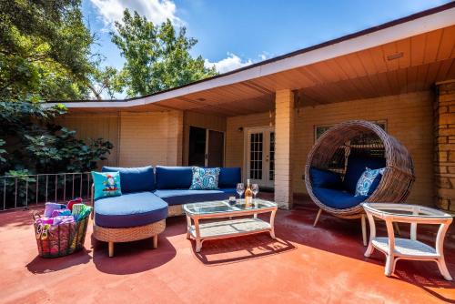 a patio with a blue couch and chairs and a swing at Riverfront Private Deck Family Games Wurstfest Fun in Seguin