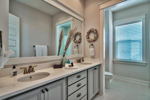 a bathroom with two sinks and a large mirror at Prominece 30A - Coasting Inn in Watersound Beach