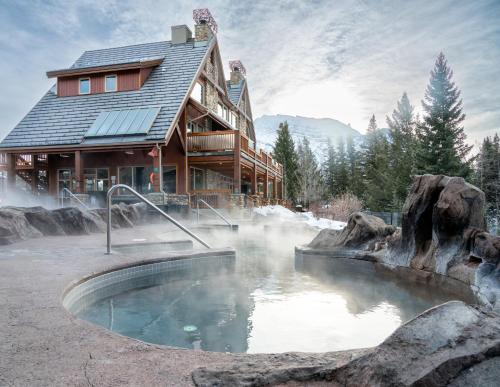 a lodge with a hot tub in front of a building at The Hidden Ridge Resort in Banff