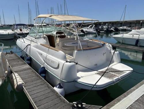 ein weißes Boot, das an einem Dock mit anderen Booten angedockt ist in der Unterkunft Barco Marina de Cascais in Cascais