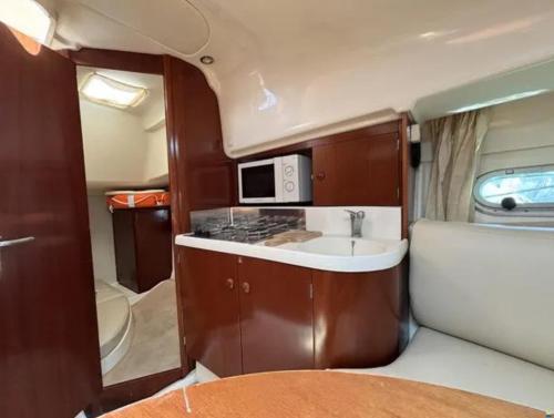 a kitchen with a sink and a microwave in an rv at Barco Marina de Cascais in Cascais