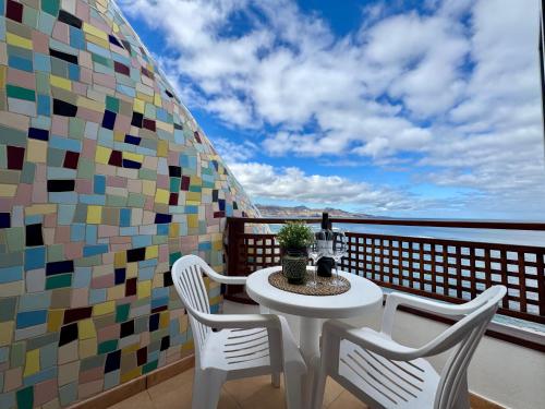 ein Tisch und Stühle auf einem Balkon mit Aussicht in der Unterkunft Canteras Ocean View in Guanarteme