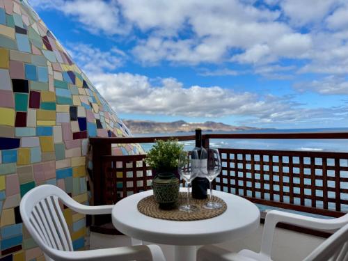 einen Tisch mit einem Glas Wein auf dem Balkon in der Unterkunft Canteras Ocean View in Guanarteme