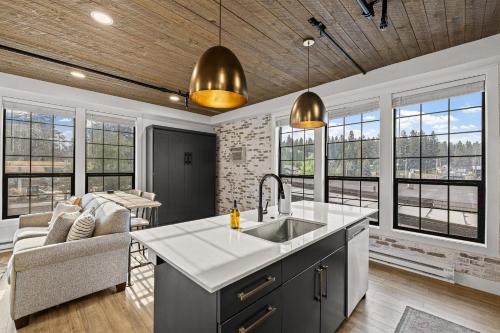 a kitchen with a sink and a living room with windows at The Loft 10 - Steps from the Lake & Dining- Newly renovated in the heart of McCall in McCall