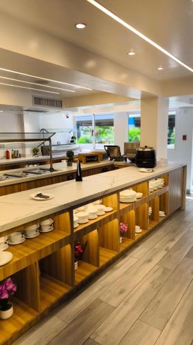 a kitchen with a large counter with wooden shelves at Hotel Margarita Dynasty in Porlamar
