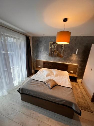 a bedroom with a bed and a large window at Garden Apart&Rooms Predeal in Predeal