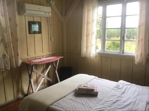 a small room with a bed and a window at Gasthaus Heimat in Rio Forcação