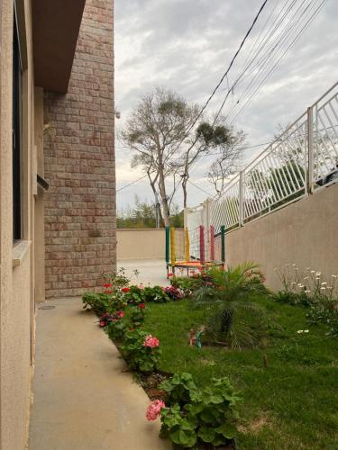 a garden with flowers next to a brick building at VEM VIVER house in Miguel Pereira