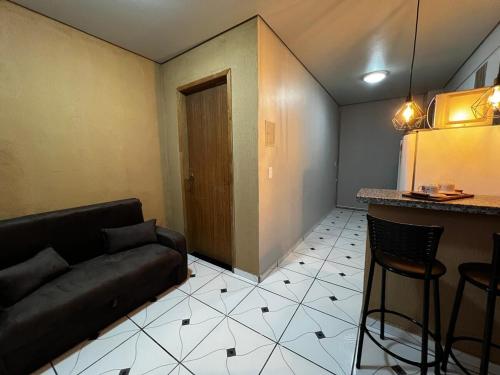 a living room with a couch and a bar at Studio prático e bem localizado em Cuiabá in Cuiabá