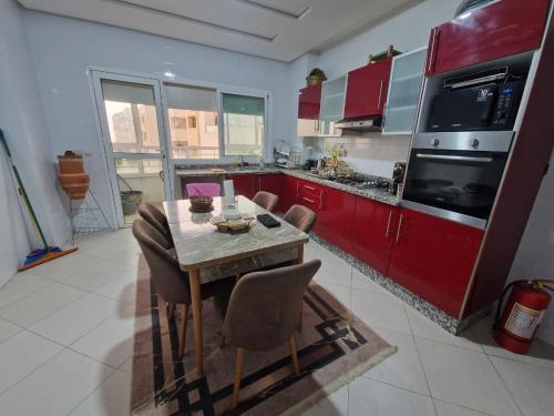 une cuisine avec des armoires rouges et une table et des chaises dans l'établissement Premium Luxury Family Home in Downtown Meknes, à Meknès