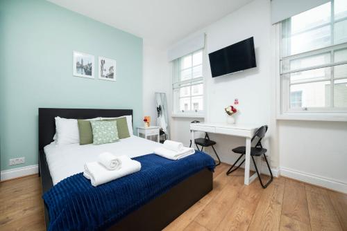 a bedroom with a bed and a desk in it at Soho Central Apartments in London