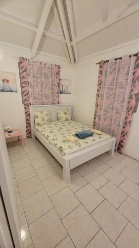 ein Schlafzimmer mit einem Bett in einem Zimmer mit Vorhängen in der Unterkunft La maison des flots in Baille-Argent