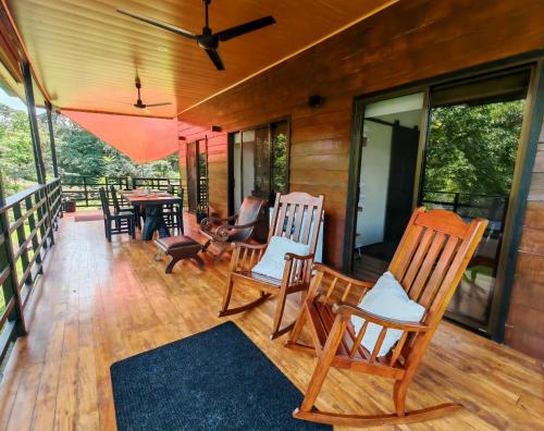 a porch with rocking chairs and a table at Ceibo Lodge in Bijagual