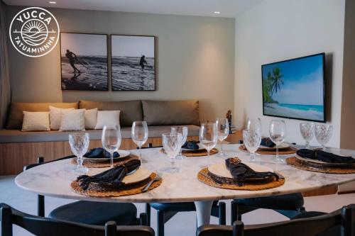 ein Esszimmer mit einem Tisch und Weingläsern darauf in der Unterkunft Yucca Tatuamunha - Naay in Tatuamunha