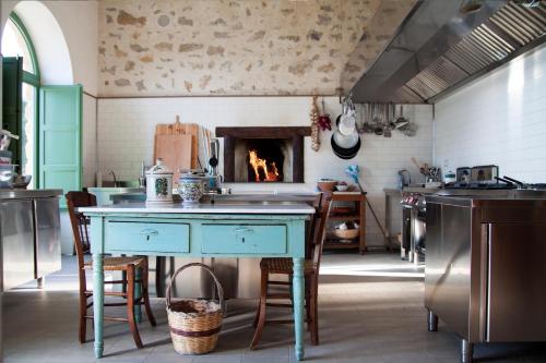 a kitchen with a table and a fireplace at Resort Fontes Episcopi in Aragona