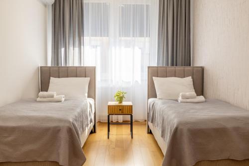 two beds in a room with a window at Premier Nova Residence in Novi Sad