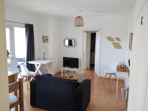 a living room with a couch and a tv at MoraSuite, dpto de categoría, céntrico, con ascensor, balcón y vistas a las sierras in Tandil