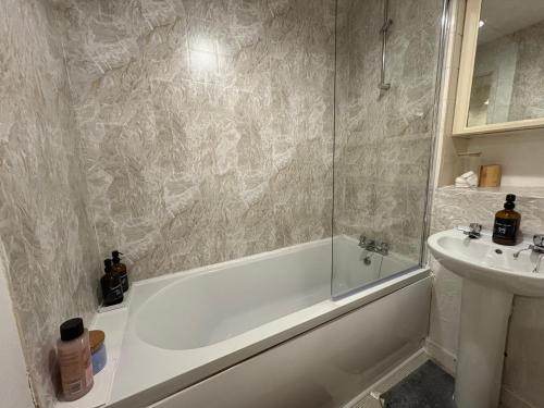 a bathroom with a bath tub and a sink at Lovely Holiday Home to explore beautiful West Wales in Carmarthen