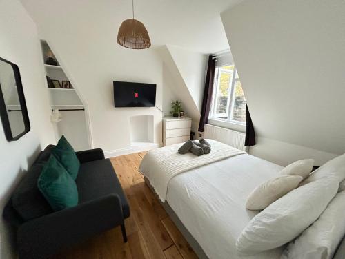 a bedroom with a white bed and a chair at Cosy 3 Bedroom Flat, Hackney Central in London