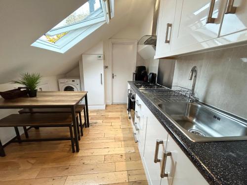 a kitchen with a table and a sink and a counter at Cosy 3 Bedroom Flat, Hackney Central in London