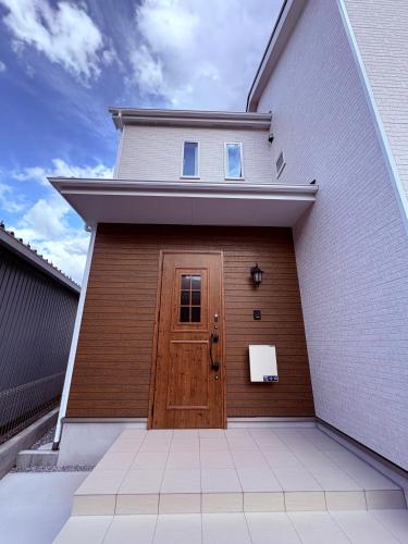 a garage with a brown door and a building at Hotel Sakura 宇都宮 in Utsunomiya