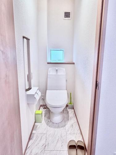 a small bathroom with a toilet and a window at Hotel Sakura 宇都宮 in Utsunomiya