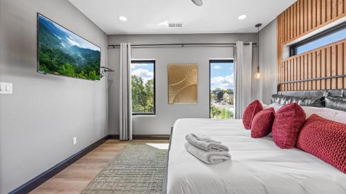 Un dormitorio con una gran cama blanca con almohadas rojas. en The Back Nine Retreat by AvantStay Private Golf Sim Firepit Mountain Views Near Dollywood, en Sevierville