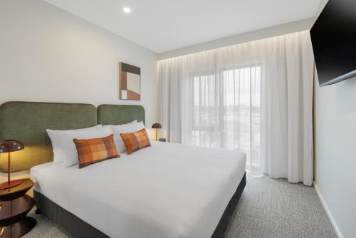 a bedroom with a large bed and a large window at Quest Bairnsdale in Bairnsdale