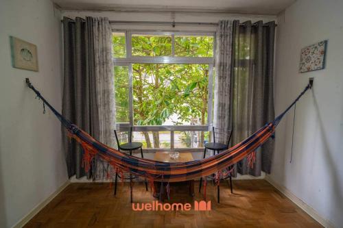 eine Hängematte in einem Zimmer mit Fenster in der Unterkunft Apartamento no Guaruja 50m da Praia das Pitangueiras in Guarujá