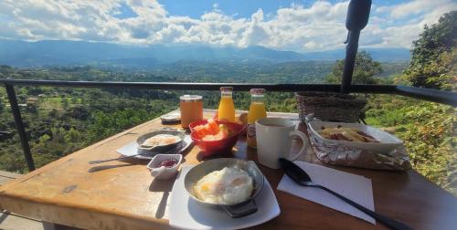 uma mesa com comida e bebidas em uma mesa com vista em Luna Menguante Refugio de Silencio y Renovación em Silvania