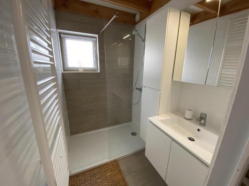 Un baño blanco con ducha y lavabo. en Westhinder I H70, en Koksijde