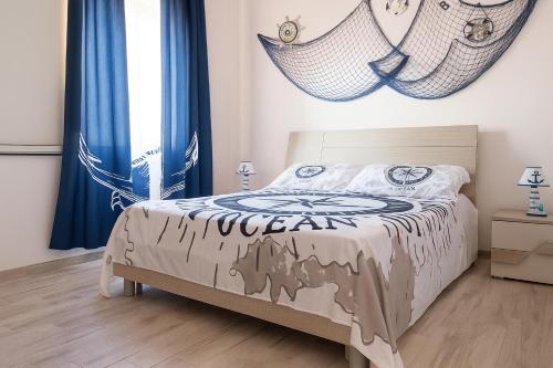 - une chambre avec un lit doté de rideaux bleus dans l'établissement Villa del Marinaio, à Mazara del Vallo