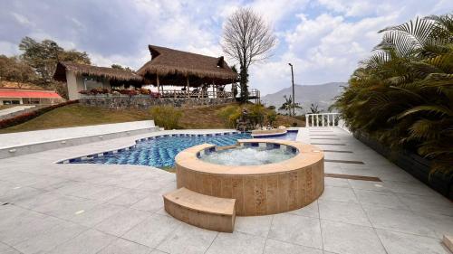ビジェータにあるVilleta Casa de Campo caracoli spaの家の前に木製の浴槽があるプール