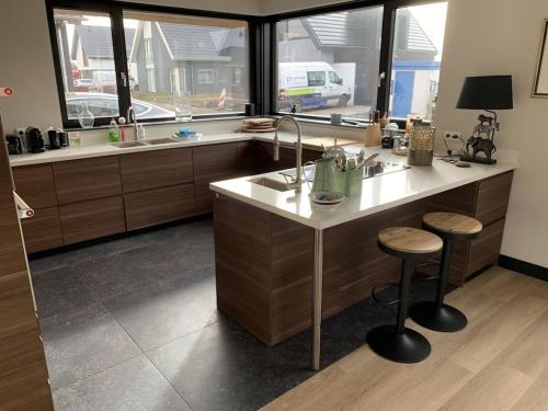 a kitchen with a counter with a sink and windows at by the water in Friesland NI in Stavoren