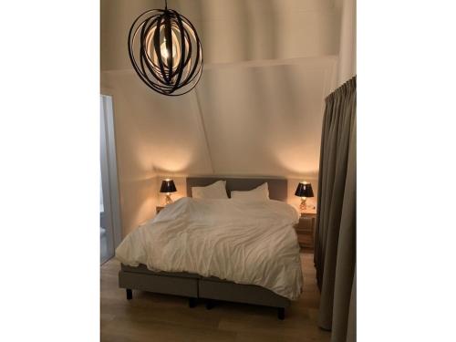 a bedroom with a bed and a pendant light at by the water in Friesland NI in Stavoren