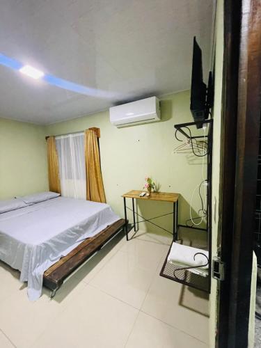 a bedroom with a bed and a flat screen tv at Cabinas Marielos in Sarapiquí