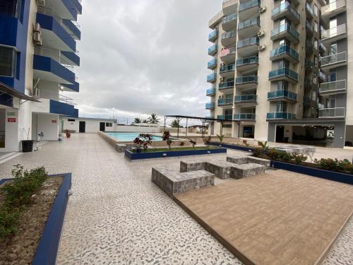 a courtyard in a building with two tall buildings at Departamento frente al mar 3 dormitorio in Tonsupa