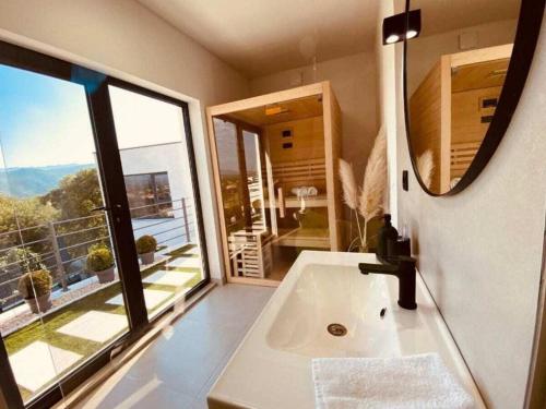 un bagno con un lavandino e una grande finestra di Magic Look with whirlpool and sauna a Donji Proložac