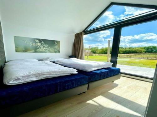 a bedroom with a bed and a large window at Cozy holiday home by the Fishing Pond in Balkbrug