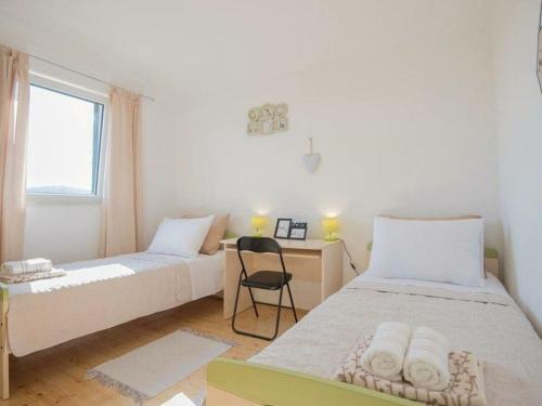 een slaapkamer met twee bedden, een bureau en een raam bij Matia I with pool in Novak