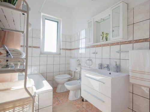 een witte badkamer met een toilet en een wastafel bij Matia I with pool in Novak