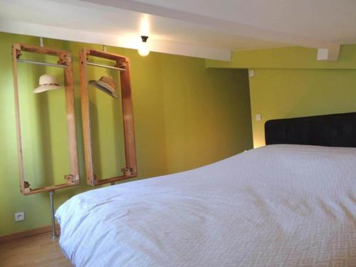 a bedroom with a white bed and green walls at Authentic Holiday Home with Charm in Marcoux