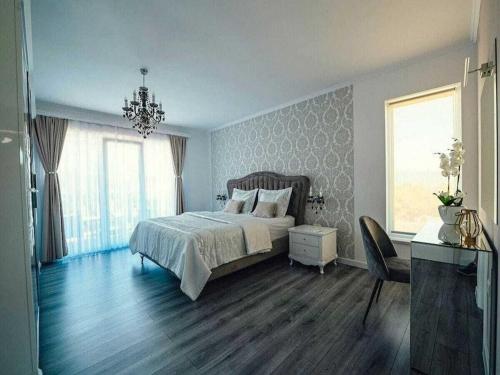 een slaapkamer met een bed en een kroonluchter bij Victoria with pool in Imotski in Ujevići